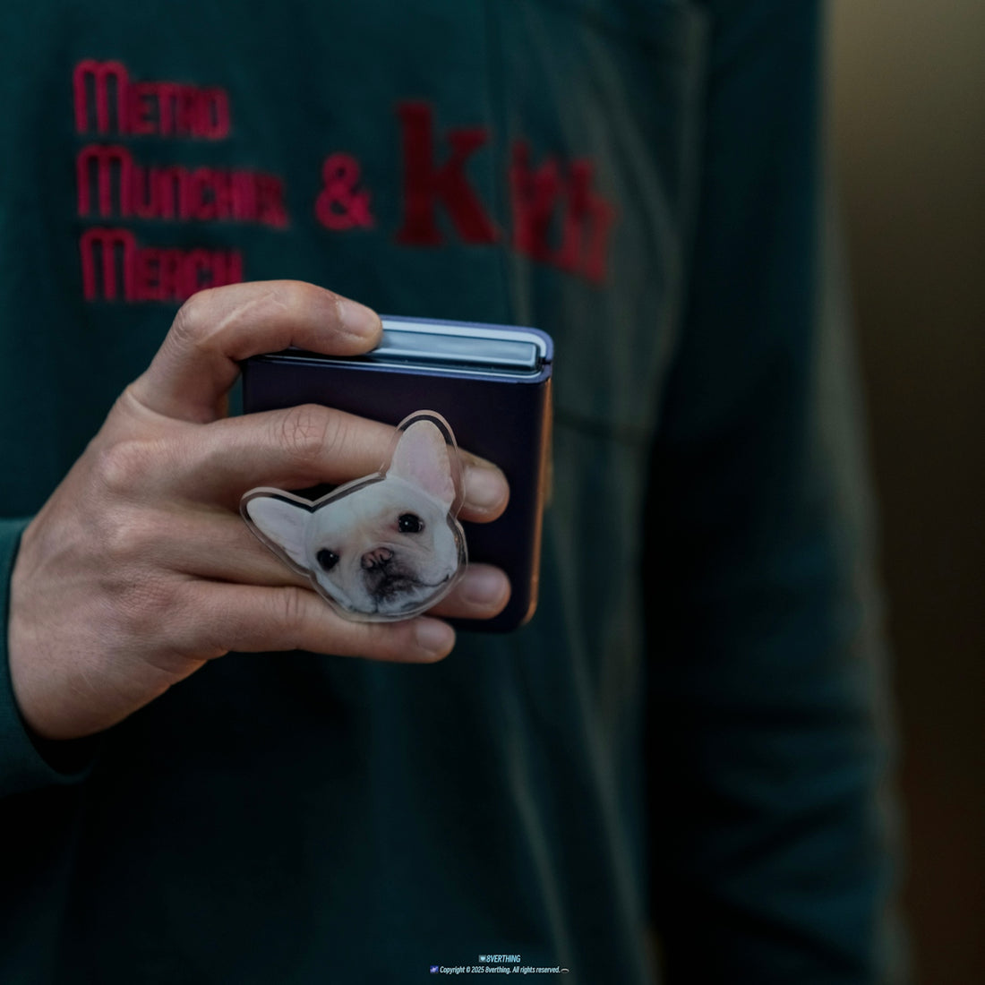 Hand holding phone with french bulldog pop socket